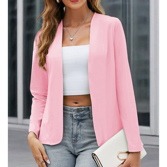 Woman wearing a pink blazer over a white top and jeans, holding a clutch.