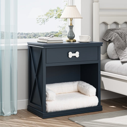 Navy blue pet bed with white cushion next to a nightstand with a lamp and books in a bedroom setting.